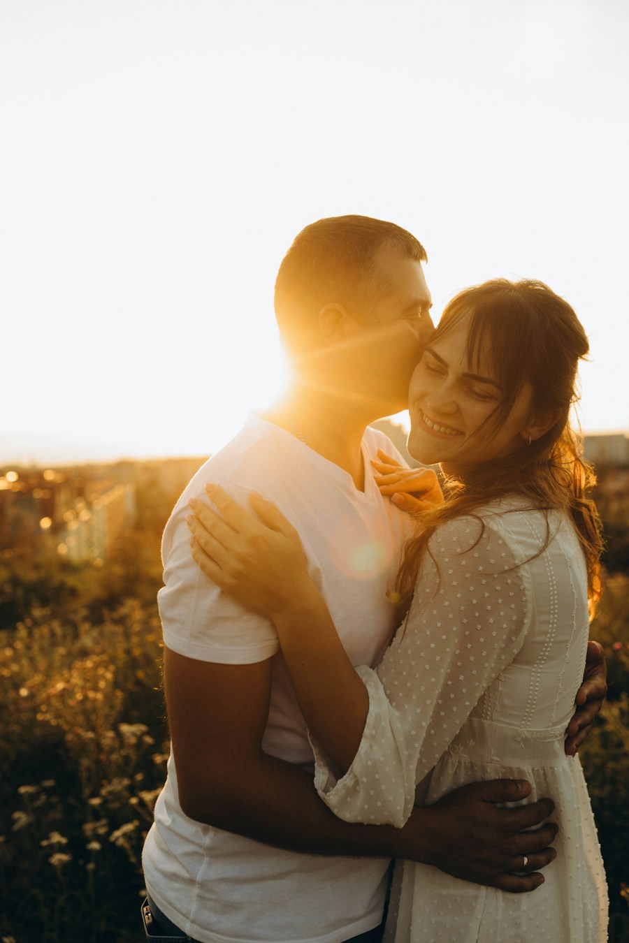 Pareja abrazada en un campo soleado