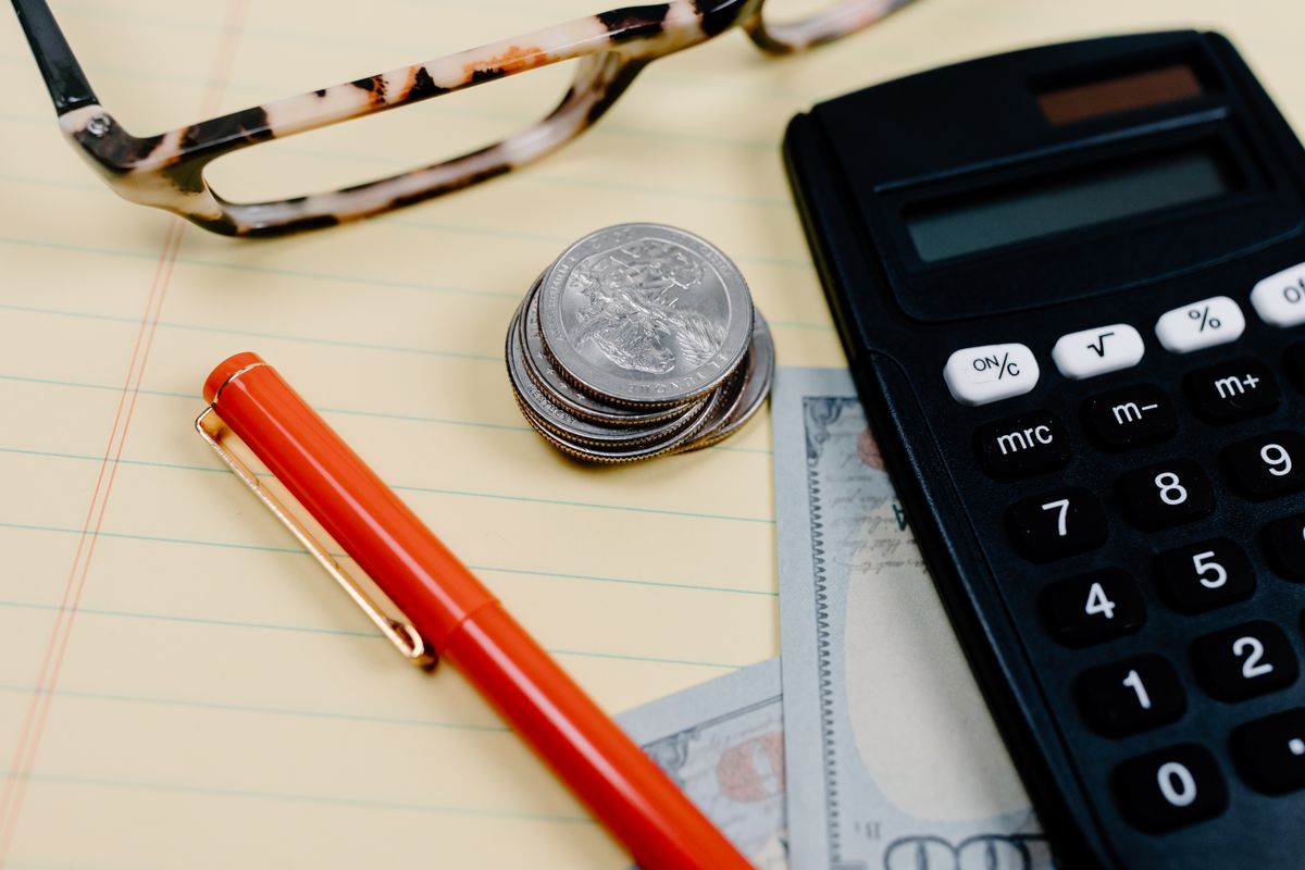 Monedas, calculadora y cuaderno para organizar las finanzas